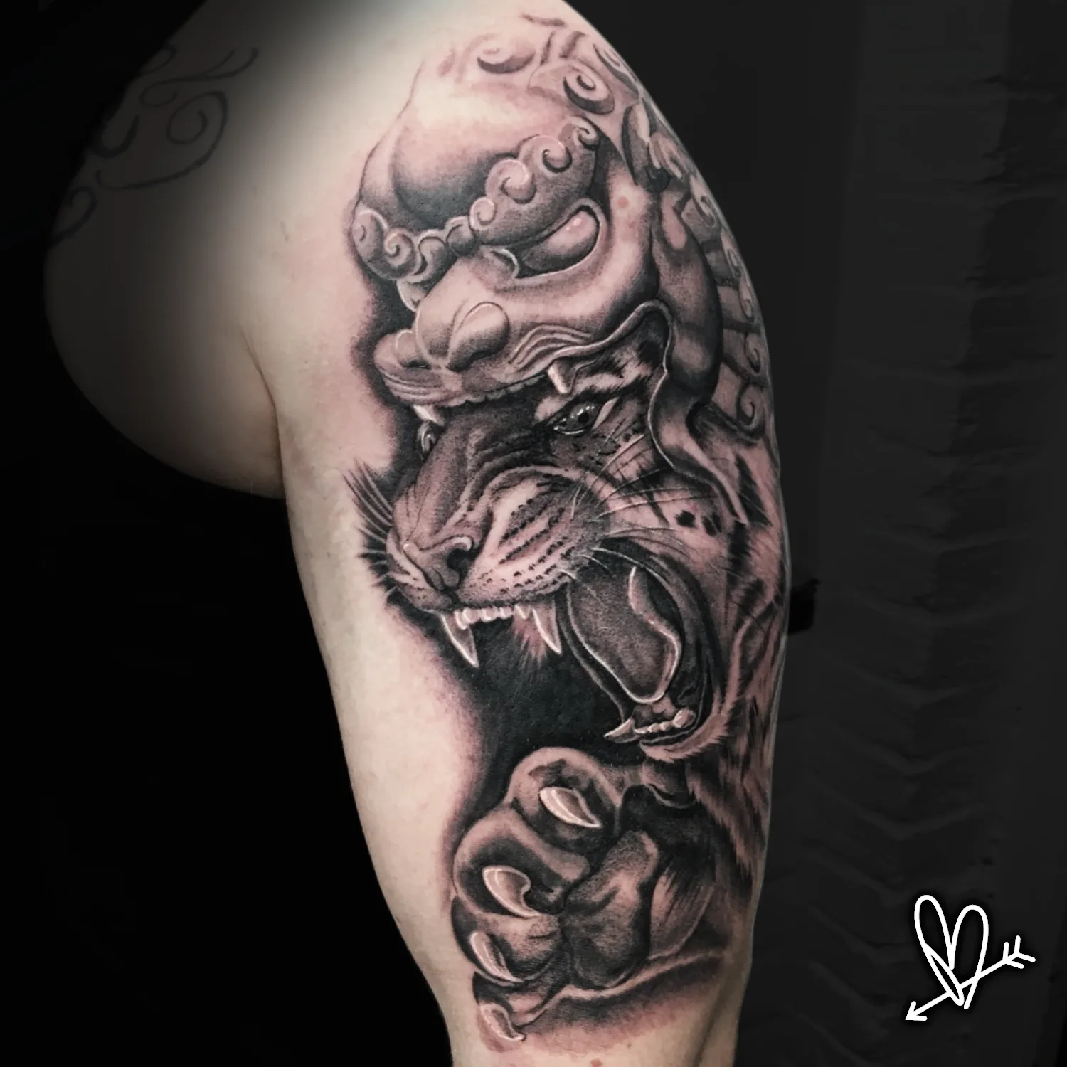 Black and grey realism foo dog tattoo on upper arm